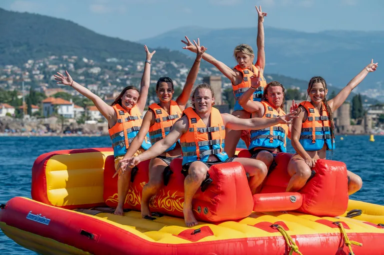 Bouée tractée à Mandelieu : groupe d'amis bras levés dans le golfe de la Napoule, près de Cannes